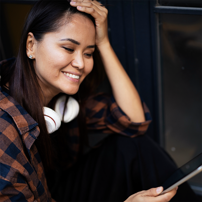 Woman enjoying music on a tablet.